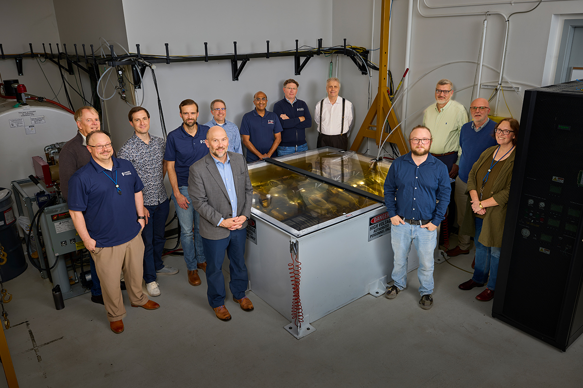 LLNL and Pacific Fusion researchers gather around the Sirius pulsed-power prototype during a May 15, 2026 celebration marking its 3,000-shot milestone.