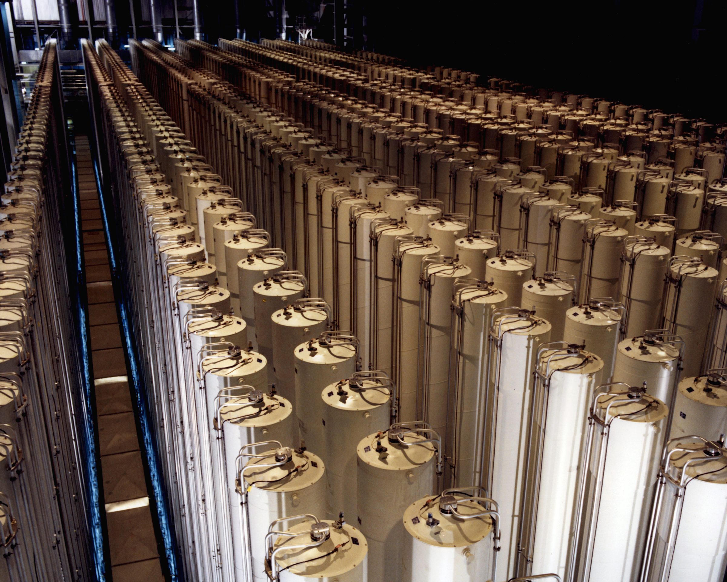Rows of tall gas centrifuges in a cascade hall at the US Department of Energy's Piketon, Ohio enrichment site, photographed in 1984
