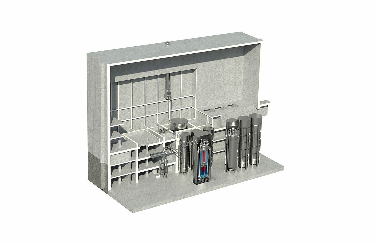Cutaway rendering of a concrete reactor building with a reactor vessel glowing red and blue inside a central pit, tall cylindrical steel vessels to its right and piping on the floors to its left
