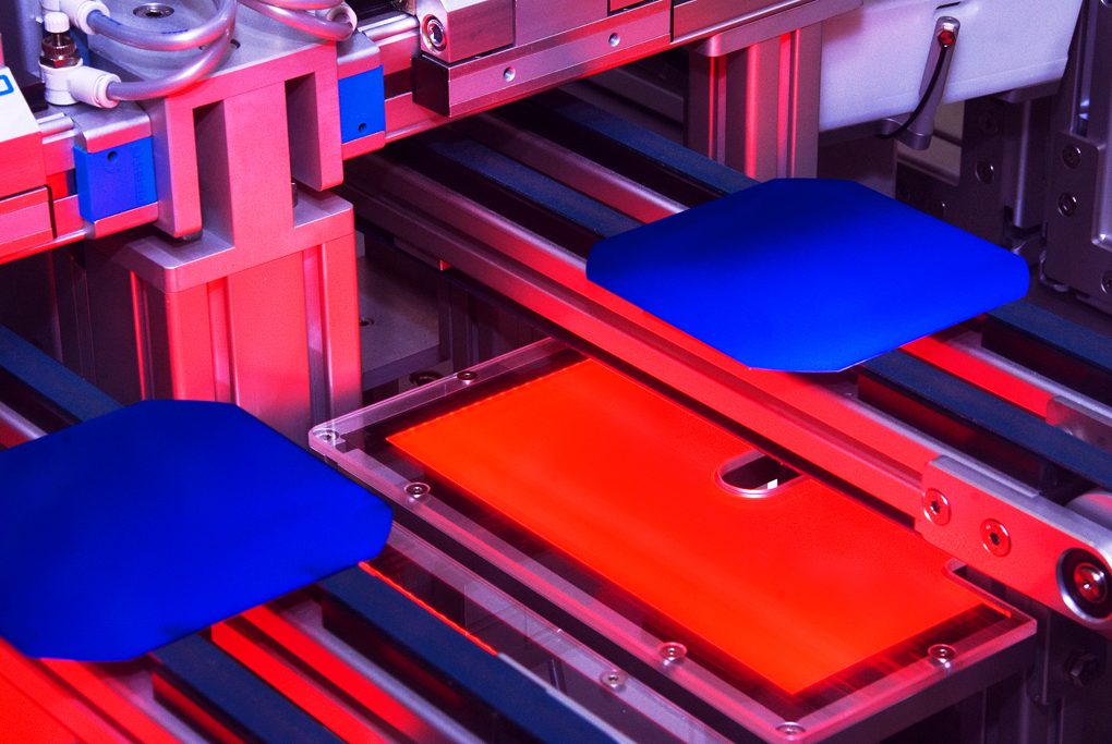 Two dark blue silicon solar wafers on a red-lit automated handling line at a SolarWorld factory, photographed in February 2009