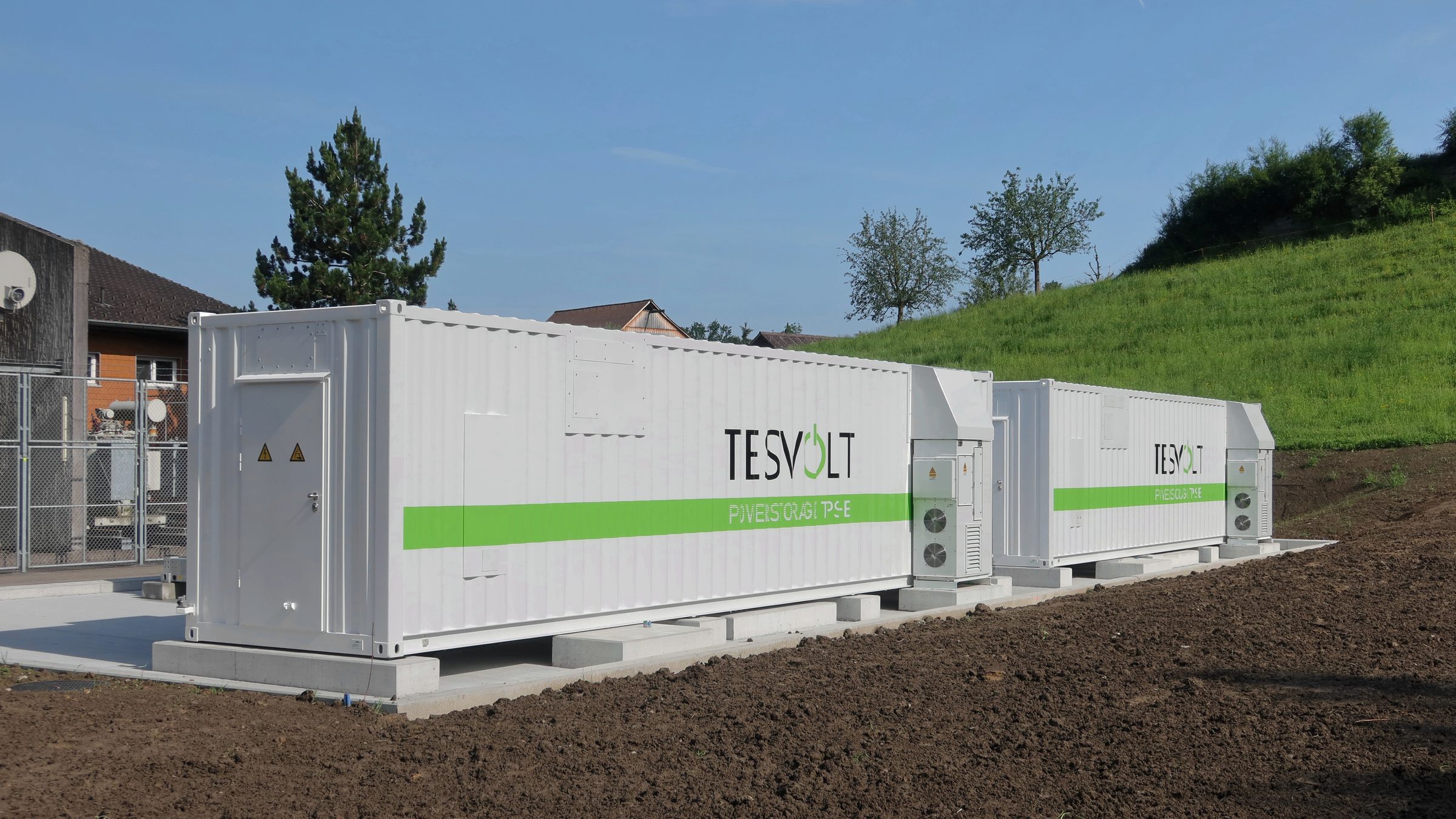 Rows of white battery storage containers at a 5 MW / 6.24 MWh battery plant in Rheineck, Switzerland